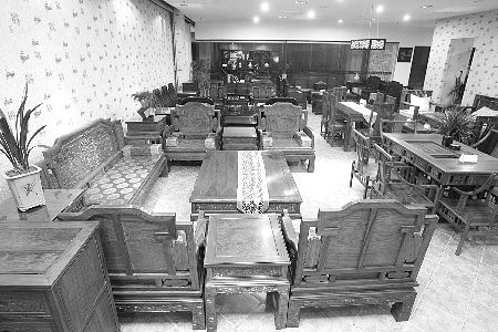 昨日，袁家岗，某家具店的红木家具无人问津。 